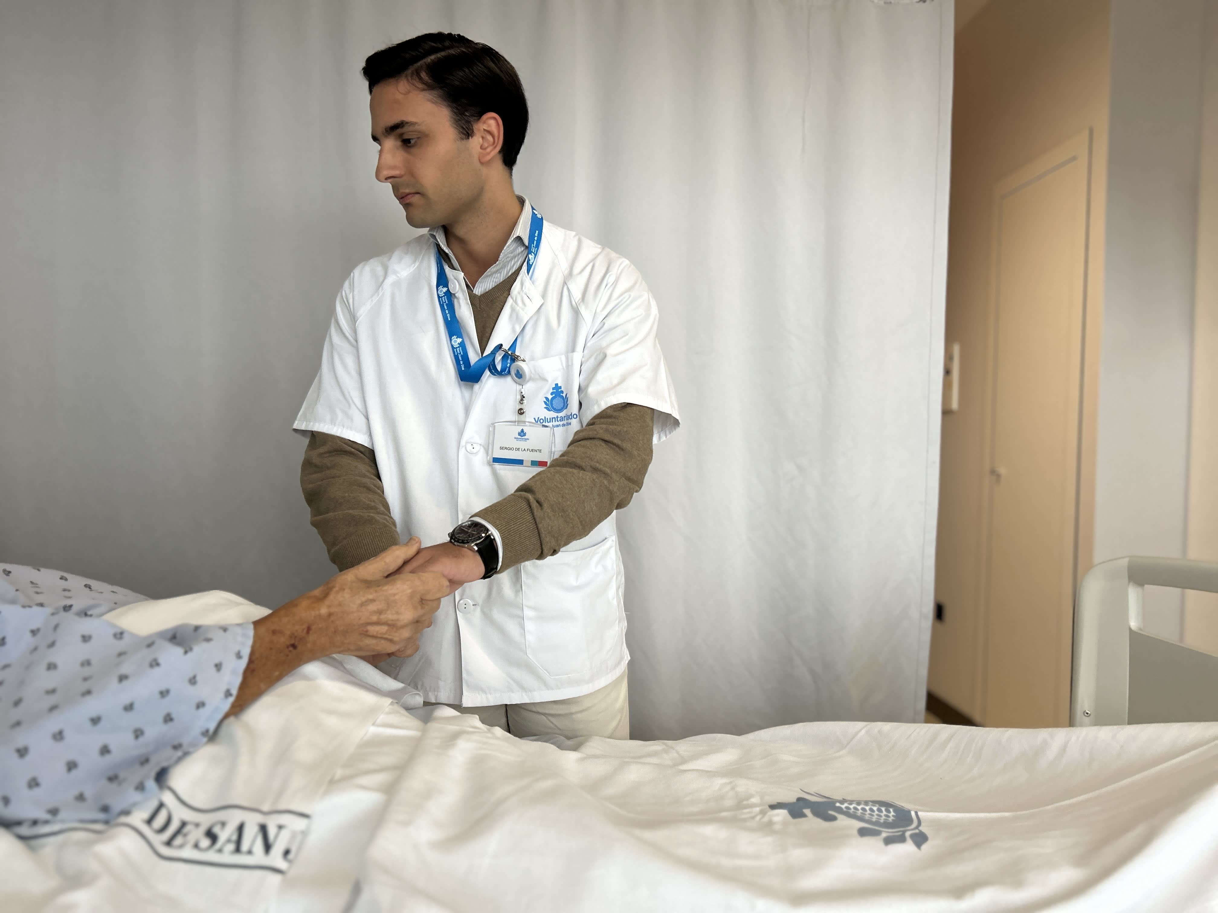 Sergio de la Fuente (21 años). Voluntario en el Hospital San Juan de Dios de Sevilla acompaña a un paciente hospitalizado
                        